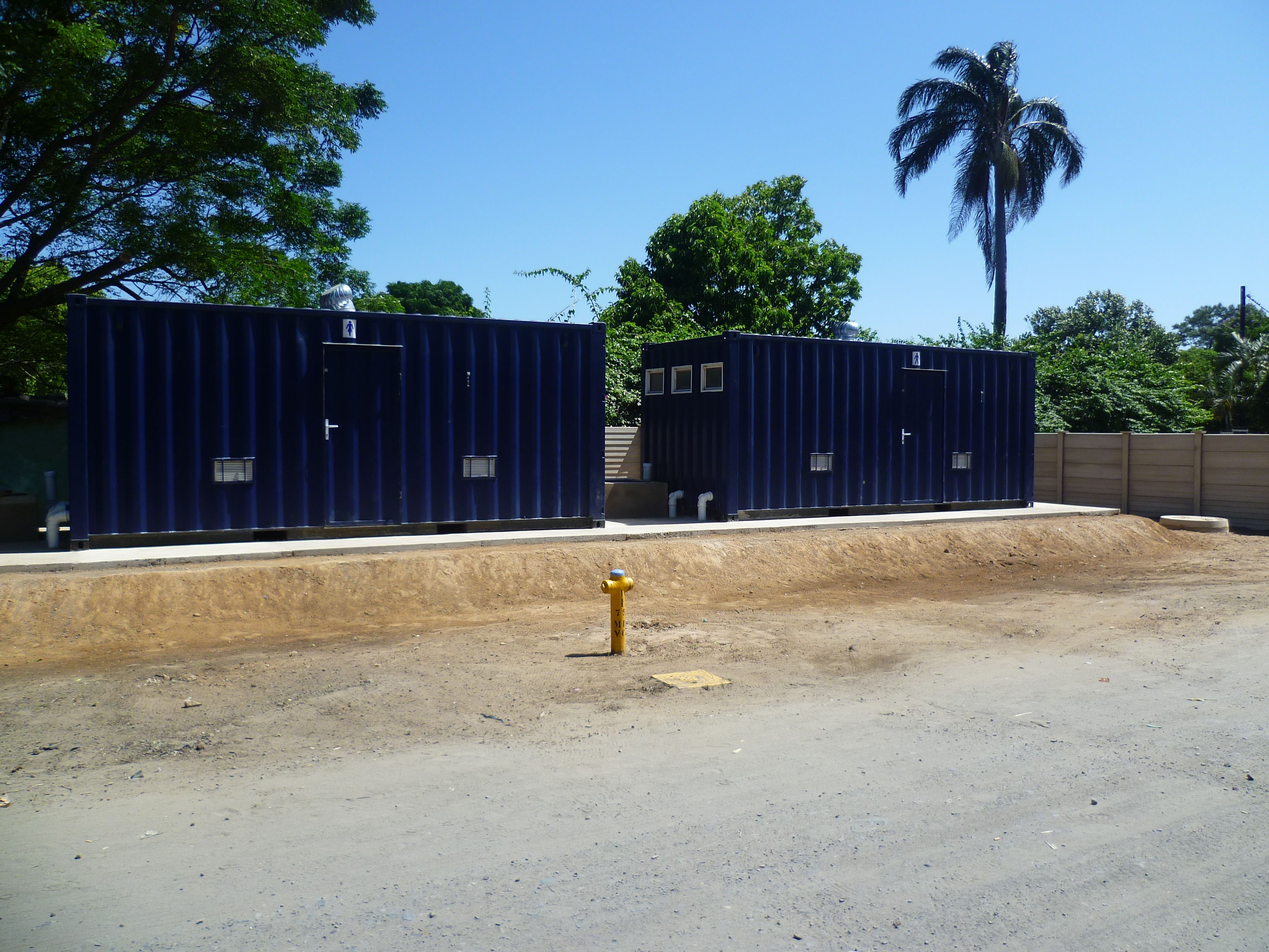 Completed container ablution blocks in South Africa with restroom signage, ventilation and plumbing connections