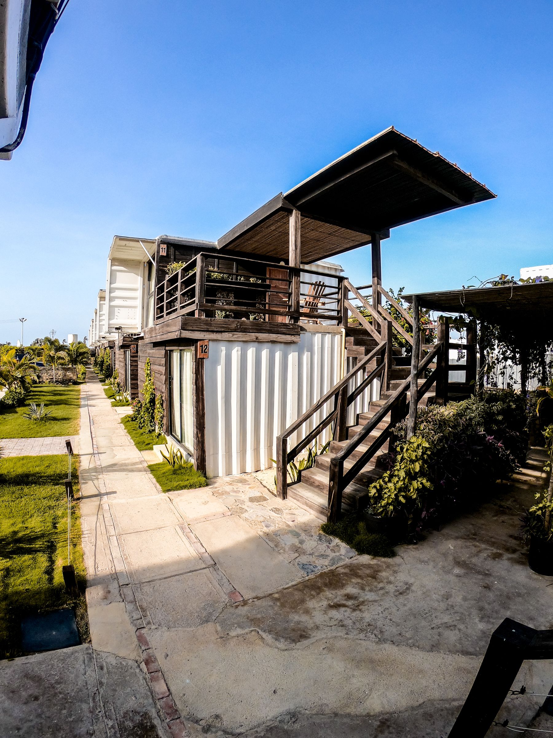 Real container accommodation finished with timber cladding, decks and shaded outdoor areas