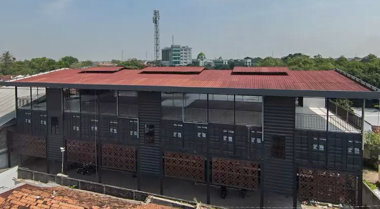 Completed modular container classroom building with shaded walkways and ventilation